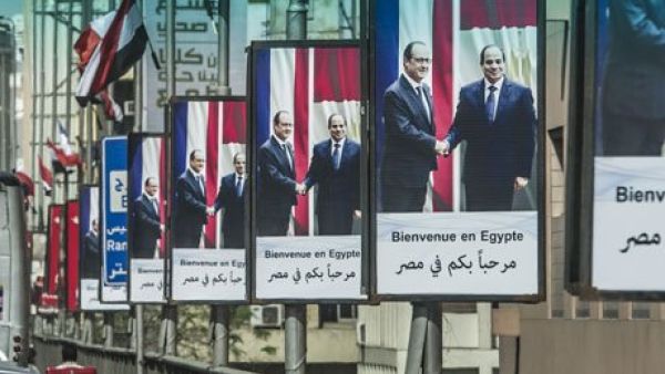 A picture taken from behind a windshield shows Egyptians driving past posters of President Abdel Fattah al-Sisi (R) and his French counterpart Francois Hollande displayed on Cairo's Six October bridge on April 17, 2016, ahead of the visit of the French president in the capital. (AFP/File)