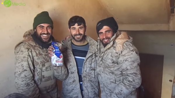 عناصر حزب الله يتضاحكون أثناء حملهم لكيس "قهوة النجار" اللبنانية في ريف حلب - يوتيوب
