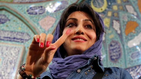 A woman shows off her ink-stained finger after voting in Tehran on Friday.  (AFP/Atta Kenare)