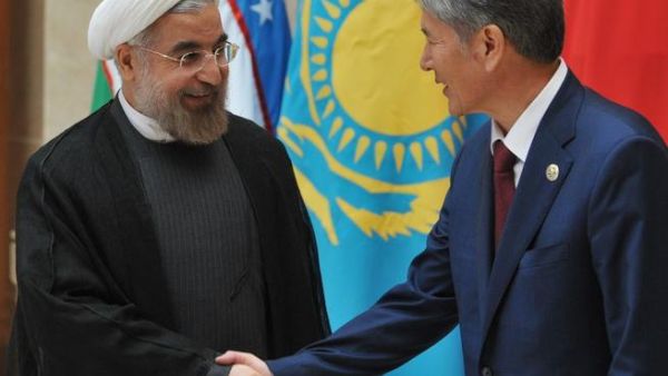 Kyrgyzstan's President Almazbek Atambayev shows the way to his Iranian counterpart Hassan Rowhani at a summit of the Shanghai Cooperation Organization. [AFP]
