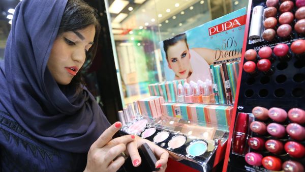 An Iranian woman checks make up at a cosmetics shop in northern Tehran on May 6, 2014. (AFP/Atta Kenare)