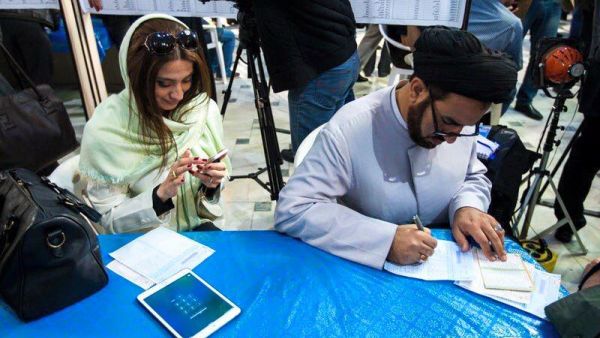 فتاة ايرانية تنتظر املاء استمارتها للتصويت 