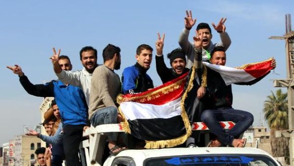 Men in Baghdad celebrate the Iraqi National Football Team's defeat of Iran in the 2015 Asian Cup on January 23, 2015.  (AFP/Ali al-Saadi)