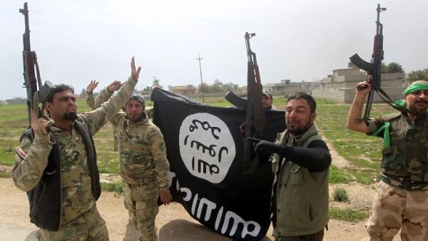 Members of the Iraqi paramilitary Popular Mobilization Forces celebrate with a Daesh flag after retaking the village of Albu Ajil near Tikrit in March 2015. (AFP/Ahmad al-Rubaye)