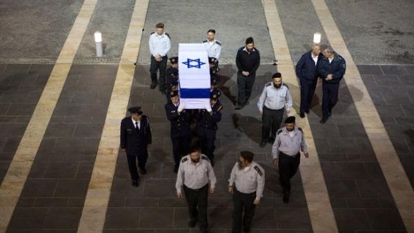 Israeli honour guards carry the coffin of former prime minister Ariel Sharon in to the Knesset (the Israeli Parliament) in Jerusalem at the end of the day on January 12, 2014 as Israelis came to pay their respects. [AFP]