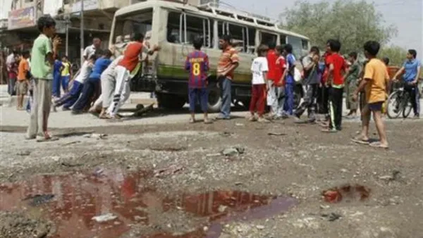 عراقيون يدفعون حافلة صغيرة تعرضت لهجوم في بغداد