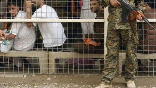 جندي عراقي يراقب سجناء في بغداد
