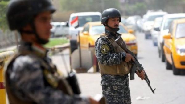 رجال من الشرطة العراقية ينشترون عند نقطة نفتيش وسط بغداد
