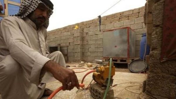 قاسم دخيل ينظر في ترقب الى خرطوم منتظرا تدفق المياه منه في مدينة الصدر