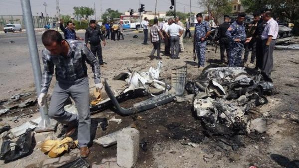 IRAQ, Kirkuk : Iraqi policemen and investigators inspect the remains of a car bomb that exploded outside the ministry of education in the northern Iraqi city of Kirkuk on August 22, 2013. AFP PHOTO MARWAN IBRAHIM