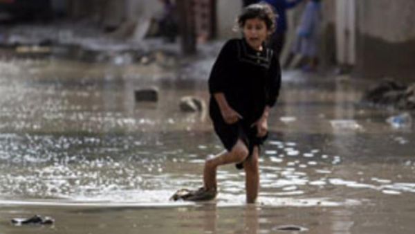 فتاة عراقية تحاول الهروب من زخات المطر