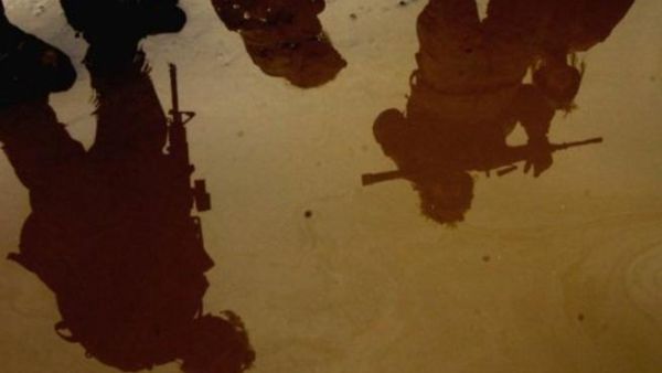 جنود اميركيون صورهم منعكسة على طريق فاضت فيه المياه في تكريت شمال العراق
