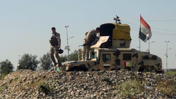 Iraqi soldiers stand near their vehicle during their withdrawal from the neighborhood of the northern Iraqi city of Kirkuk on April 27, 2013. (AFP/Marwan Ibrahim)