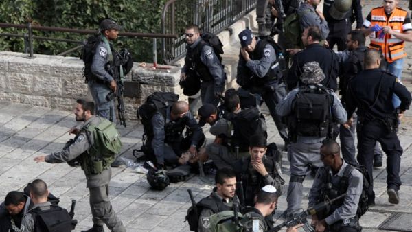 Israeli border guards give first aid to an injured police officer, who was stabbed along with another officer by a Palestinian, on October 10, 2015. (AFP/Gali Tibbon) Israeli border guards give first aid to an injured police officer, who was stabbed along with another officer by a Palestinian, on October 10, 2015. (AFP/Gali Tibbon)