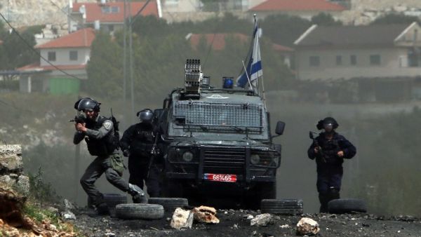 Israeli security forces take aim during clashes with Palestinian protesters following a weekly demonstration against the expropriation of Palestinian land by Israel in the village of Kfar Qaddum, near Nablus, in the occupied West Bank, on April 8, 2016. (AFP/Jaafar Ashtiyeh)