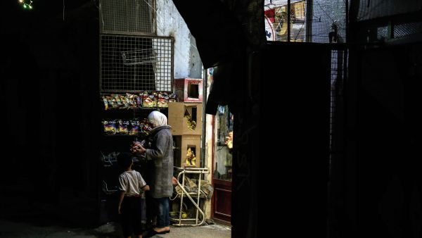 A Syrian woman buys chips at a shop in Tishreen, a northwestern rebel-held suburb of the capital Damascus, during the Muslim holy fasting month of Ramadan on June 28, 2016. (AFP photo)