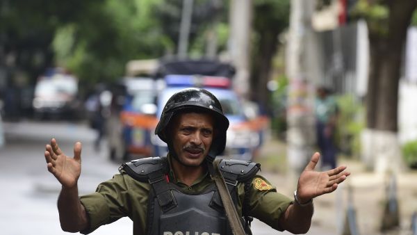 A Bangladeshi police officer gestures during a rescue operation as gunmen take position in a restaurant in the Dhaka’s high-security diplomatic district on July 2, 2016 where several people including foreigners are believed to be trapped. (AFP photo)