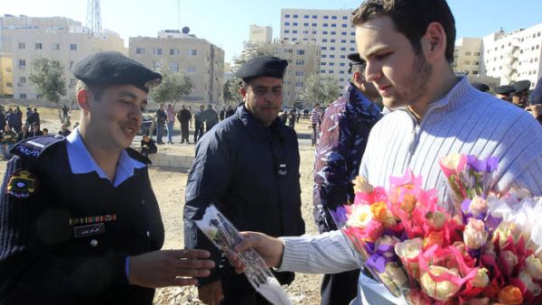 متظاهر يهدي ورودا لرجال الشرطة خلال مسيرة نظمتها المعارضة الجمعة في العاصمة الاردنية عمان/أ.ف.ب