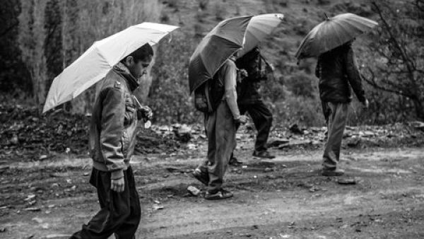 Xana going to school with his friends on a rainy day. Because his village does not have a junior high school, Xana must travel to school in the next village, seven kilometers, or about 4.3 miles, from home. (Photo credit: Arash Khamooshi)