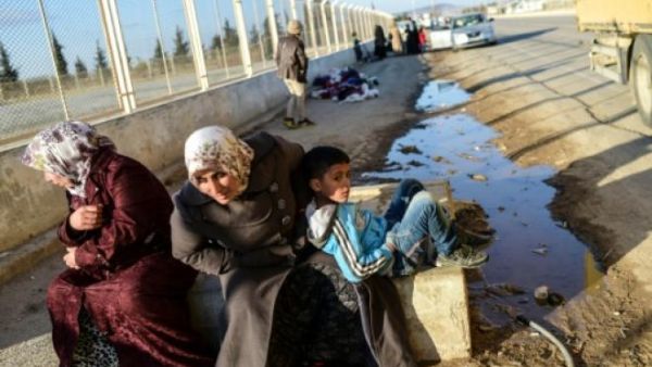 Two Syrian women and a boy wait in front of Oncupinar crossing gate, near the town of Kilis, to return to Syria on February 9, 2016. (AFP file)