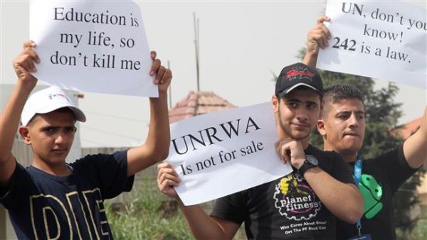 Palestinian refugees living in Jordan hold placards during a demonstration against the planned cuts in services related to the United Nations Relief and Works Agency (UNRWA)’s education program, August 5, 2015. [AFP]