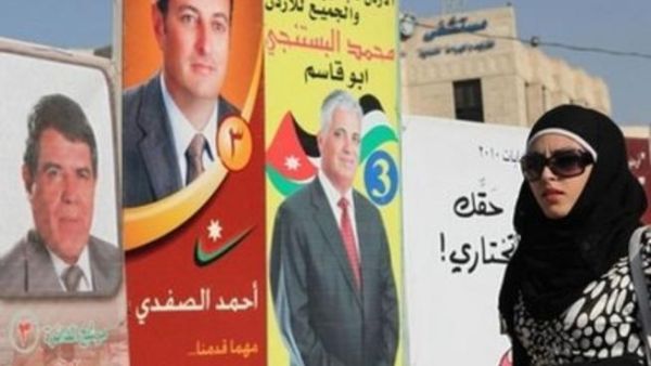 امراة تمر امام لافتات انتخابية لمرشحين في العاصمة عمان