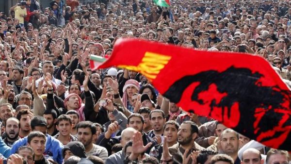 متظاهرون في وسط العاصمة عمان يلوحون براية كبيرة عليها صورة الثائر اللاتيني تشي غيفارا/أ.ف.ب