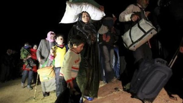 In darkness, Syrian refugees stream across country borders. [Reuters]