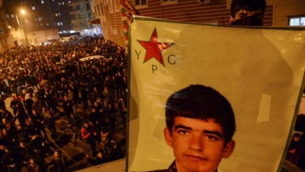 A Kurdish youth holds a picture of a YPG fighter killed in Kobane during a celebration in Diyarbakir on Jan. 26, 2015. (AFP/File)