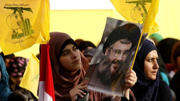 Lebanese women wave Hezbollah flags while holding a picture of the movement's chief Hassan Nasrallah in Mashghara in the western Bekaa Valley on May 25 (MahmoudZayyat / AFP)