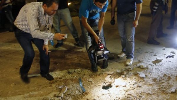 LEBANON, BAABDA : Lebanese people and journalists inspect the damage at a private residence where one of two rockets fired from an unknown location exploded in the early hours of August 2, 2013, just metres from an entrance to the presidential palace in Baabda, around eight kilometres southeast of the Lebanese capital Beirut.  AFP PHOTO / ANWAR AMRO