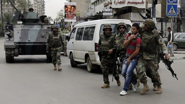 Lebanese soldiers arrest a man in Tripoli after fighting broke out in the city (AFP Photo)