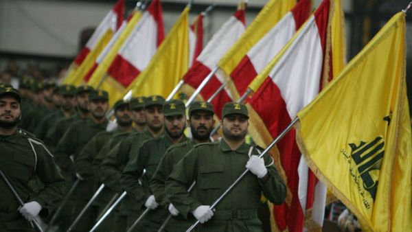  Hezbollah fighters, holding up Lebanese flags and the yellow flag of the militant Shiite Muslim group. AFP PHOTO/RAMZI HAIDAR
