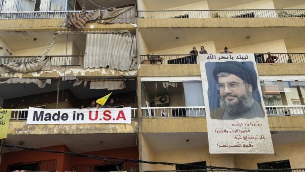 LEBANON, Beirut : Lebanese people hand a poster of Hassan Nasrallah, the head of Lebanon's militant Shiite Muslim movement Hezbollah, from their balcony. AFP PHOTO / ANWAR AMRO