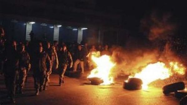 جنود لبنانيون يسيرون قرب اطارات اشعلها انصار الحريري في احد الشوارع الرئيسية