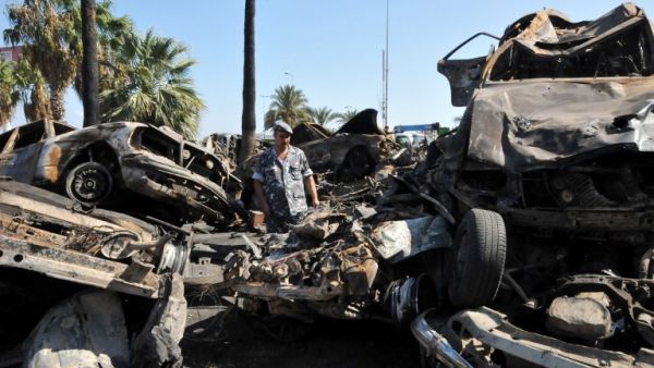 LEBANON, Tripoli : A Lebanese soldier inspect burnt vehicles on August 24, 2013 on the site of a bombing outside Al-Taqwa mosque the day before in the northern city of Tripoli. AFP PHOTO IBRAHIM CHALHOUB