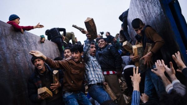 People rush to get firewood in a makeshift camp of the Greek-Macedonian border near the Greek village of Idomeni on March 6, 2016. (AFP/Dimitar Dilkoff)