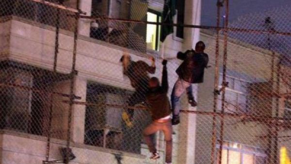 متظاهرون يتسلقون سياج القنصيلة قبل احراقها