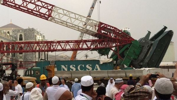 Pilgrims walk near the construction crane which crashed in Mecca's Grand Mosque on September 11, 2015, killing more than 100 and injuring over 200 others. (AFP)
