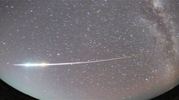 AUSTRALIA, Woomera : A handout photo taken with a fish-eye lens on June 13, 2010, and released on June 14 shows the capsule carried by the Hayabusa spacecraft burning up over South Australia on re-entry, leaving the heat-resistant pod to parachute back to land within the Woomera military zone.  