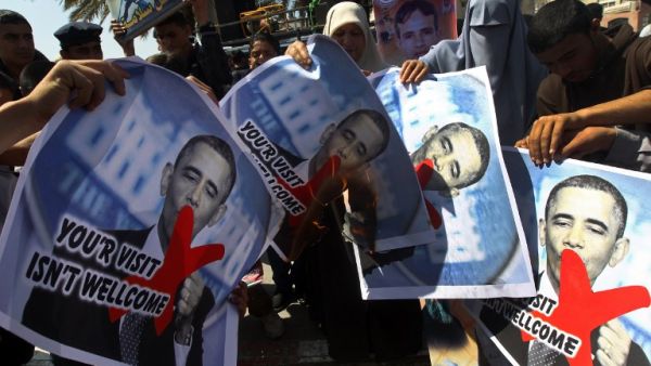 Relatives of prisoners of Palestinians held in Israeli jails burn pictures of US President Barack Obama during a protest against his visit to the region at the Jabalyia refugee camp, in the northern Gaza Strip. (AFP PHOTO / MAHMUD HAMS)