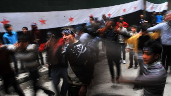 Syrian protestors dance during an anti-regime demonstration in the northern city of Aleppo on March 22, 2013. EU foreign ministers mulled a contested push by Britain and France to lift or amend a Syria arms embargo to help tip the balance in the country's more than two-year conflict. (AFP PHOTO/BULENT KILIC)