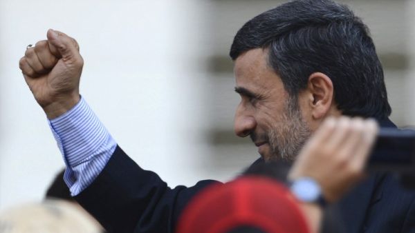 Iran's President Mahmoud Ahmadinejad raises his clenched fist in salutation during the funeral of Venezuela's President Hugo Chavez in Caracas. (AFP PHOTO/JUAN BARRETO)