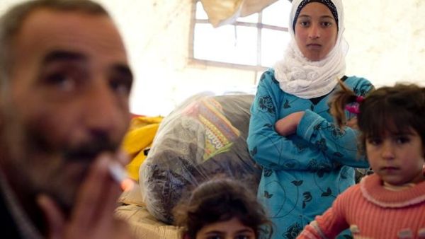 A Syrian refugee family gathers inside a tent after fleeing from the northern Syrian town of Darkush.( AFP PHOTO / ODD ANDERSEN)
