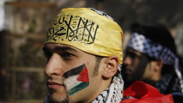 A Palestian wearing the trademark chequerred keffieyh with a national flag painted on his face, attends a rally in support of president Mahmoud Abbas's Farah party on Friday in Gaza City. (AFP PHOTO / MOHAMMED ABED)