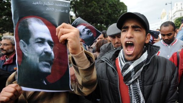A Tunisian protestor holds a placard featuring killed opposition leader Chokri Belaid during a demonstration. (AFP PHOTO / FETHI BELAID)