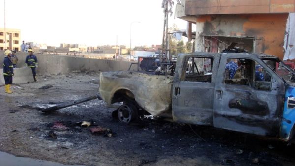 Iraqi security and fire fighters secure the scene following a car bomb, in the northern city of Kirkuk on March 5, 2013. (AFP PHOTO/MARWAN IBRAHIM)