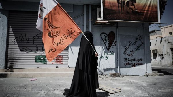 A Bahraini woman holds up her national flag decorated with anti-government slogans in the village of Jidhafs, west of Manama. (AFP PHOTO/MOHAMMED AL-SHAIKH)