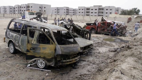 Iraqi emergency personnel and civilians gather around the site of a car bomb explosion near the outskirts of the south Iraq city of Basra, on March 17, 2013, killing 10 people and wounding 16, the head of the Basra provincial council security committee said. (AFP PHOTO/STR)