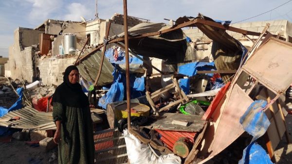 An Iraqi woman inspects the damage following a car bomb attack that happened late at night in Kirkuk, 240 kilometers north of Baghdad, on March 20, 2013, that killed one and wounded several. (AFP PHOTO / MARWAN IBRAHIM)